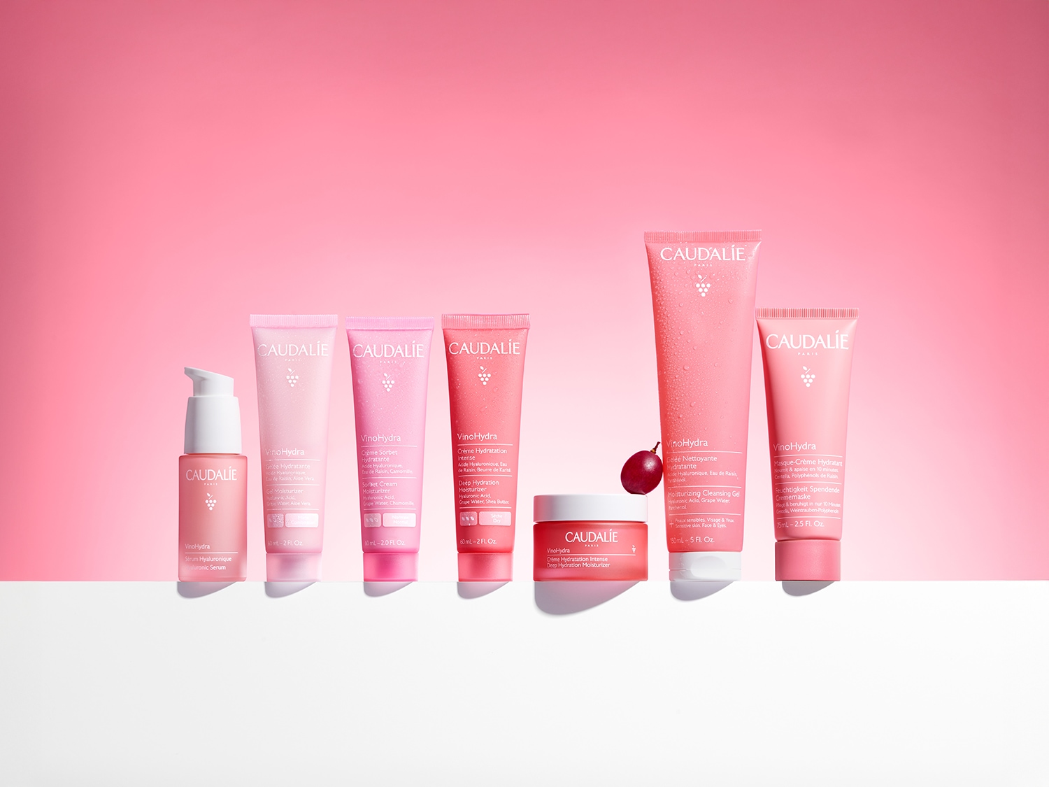 Eine Auswahl an VinoHydra-Hautpflegeprodukten von Caudalie in rosafarbenen Verpackungen, die Feuchtigkeit spenden und die Haut pflegen.