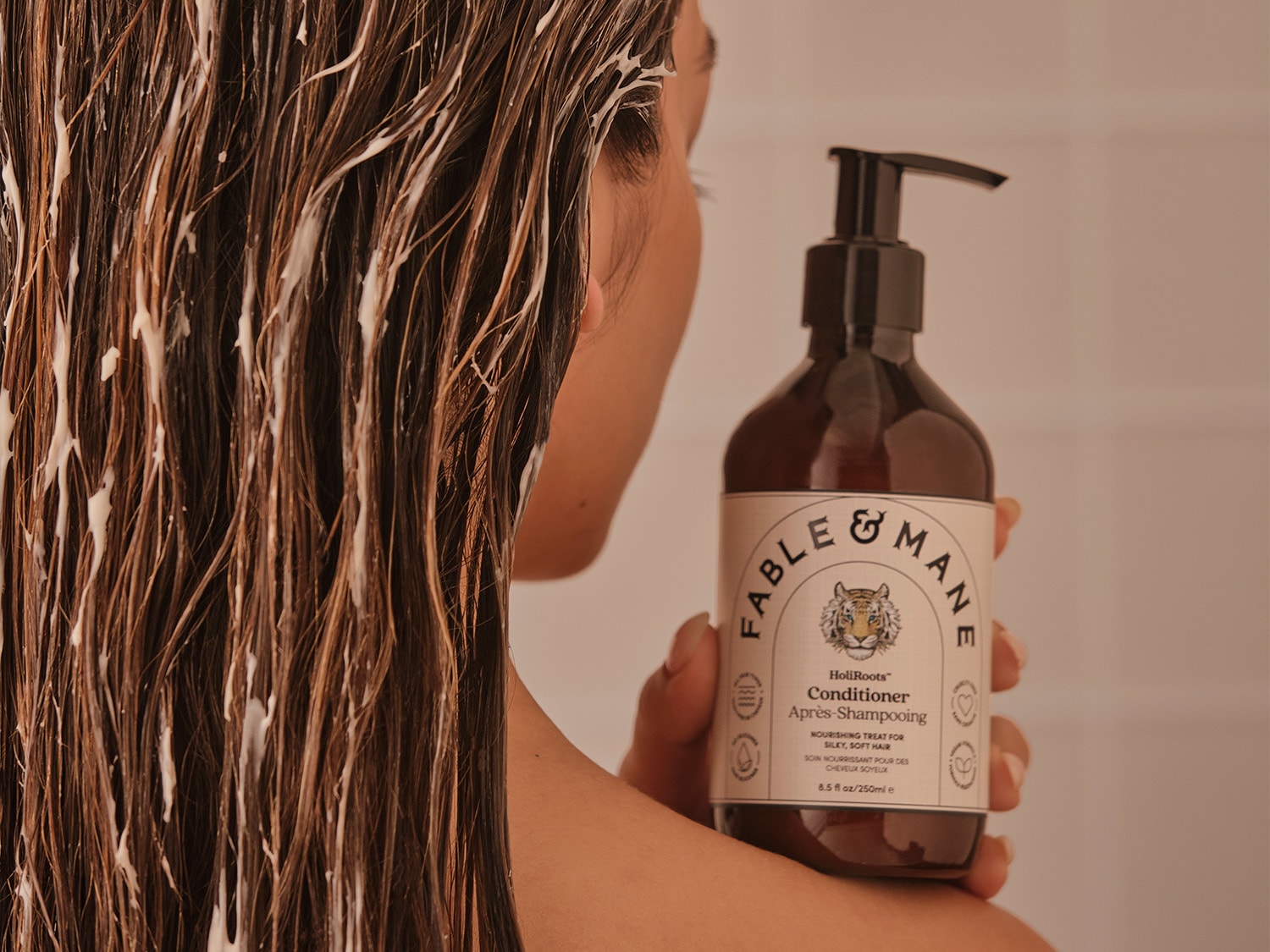 Voici un après-shampoing Fable & Mane HoliRoots™ dans un flacon marron foncé, conçu pour nourrir et adoucir les cheveux.