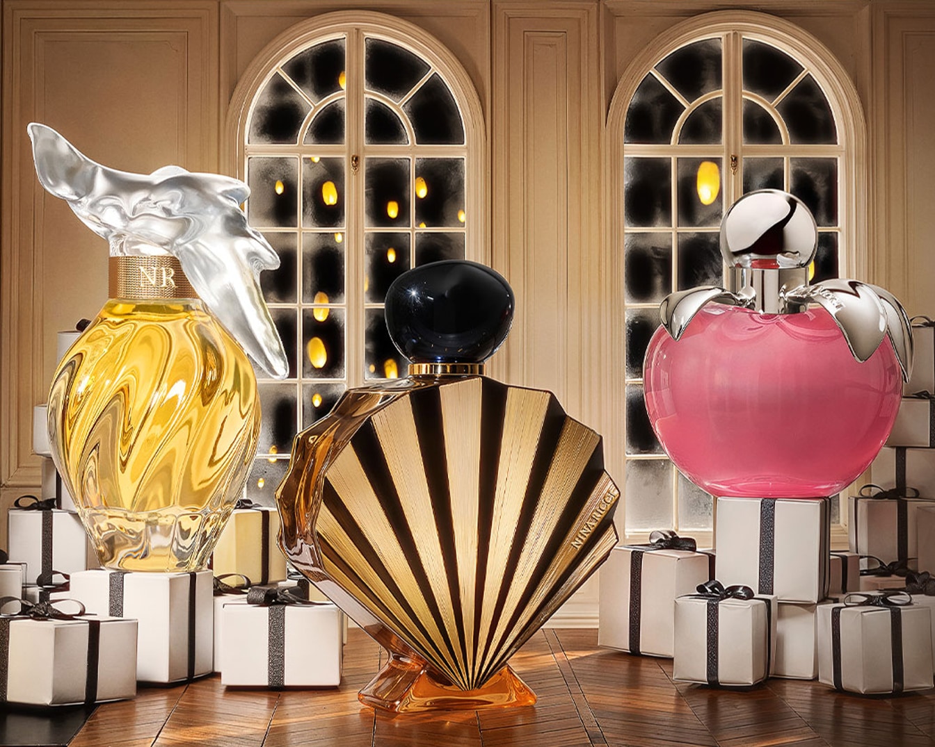Découvrez trois parfums Nina Ricci : un flacon doré avec un bouchon en forme d'oiseau, un flacon éventail doré et noir, et un flacon rose en forme de pomme, tous présentés sur des cadeaux.