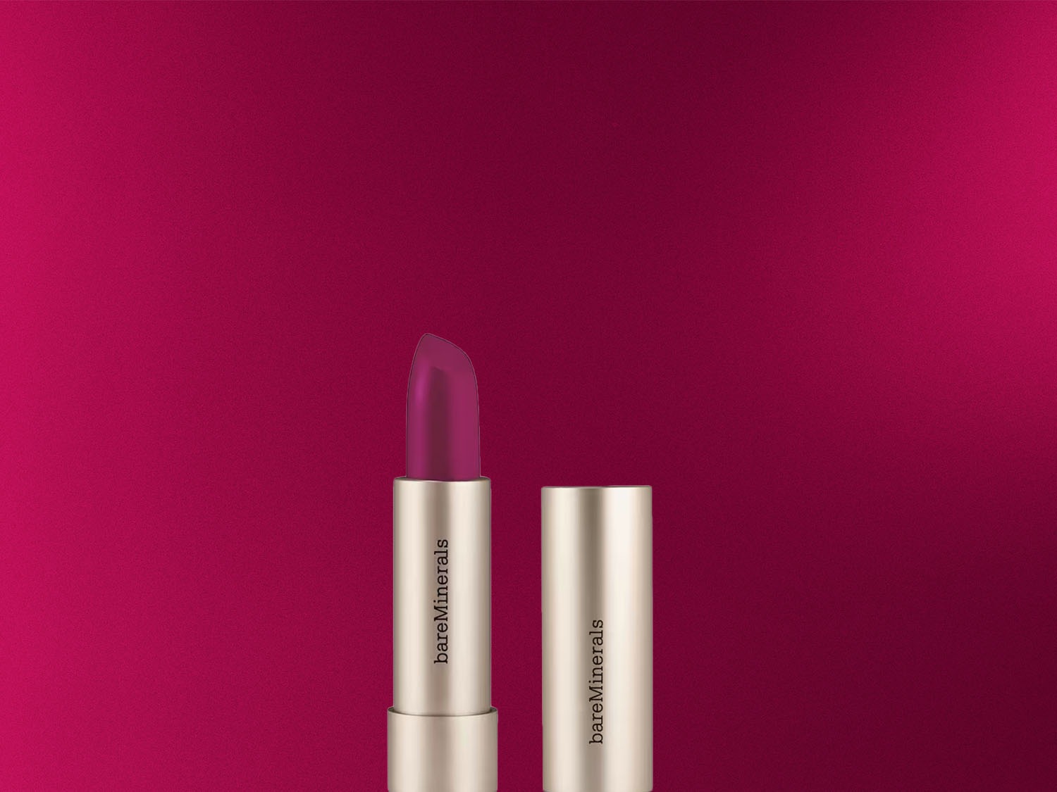 Na burgundskom pozadí je zobrazený rúž bareMinerals s otvoreným viečkom, ktorý odhaľuje ružovkastý odtieň.