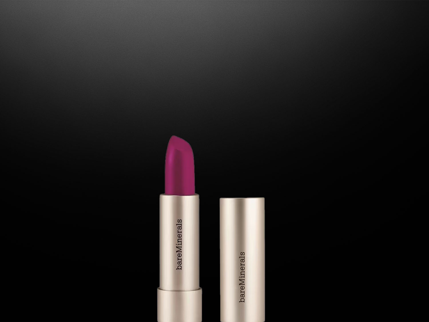 Na čiernom pozadí je zobrazený rúž Bare Minerals s otvoreným viečkom, ktorý odhaľuje sýto ružový odtieň.