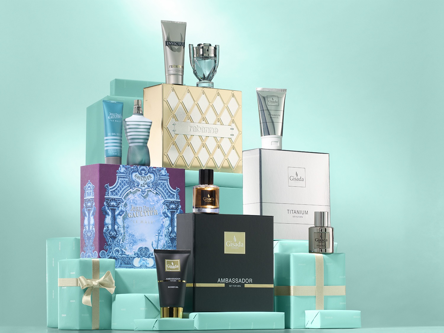 Una piramide di regali in carta azzurra con fiocchi dorati mette in mostra set regalo di profumi e prodotti per la cura della persona di marchi come Jean Paul Gaultier, Rabanne e Gisada.