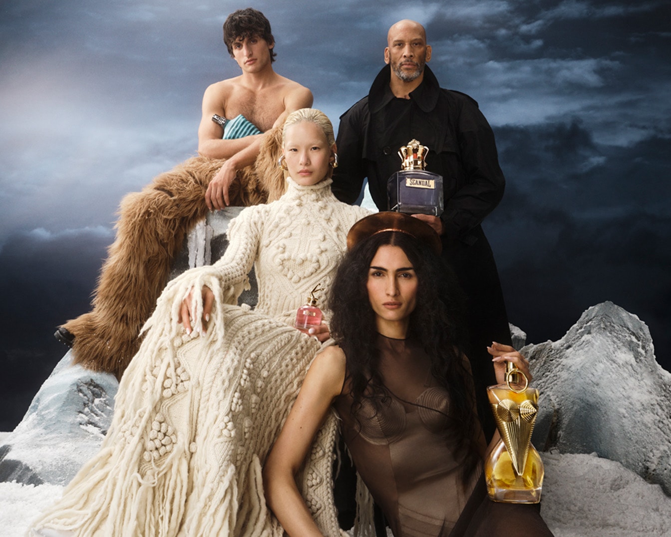 Keturi modeliai pozuoja su „Jean Paul Gaultier“ aromatais ant snieguoto kraštovaizdžio fono, pabrėždami prabangą ir drąsą.