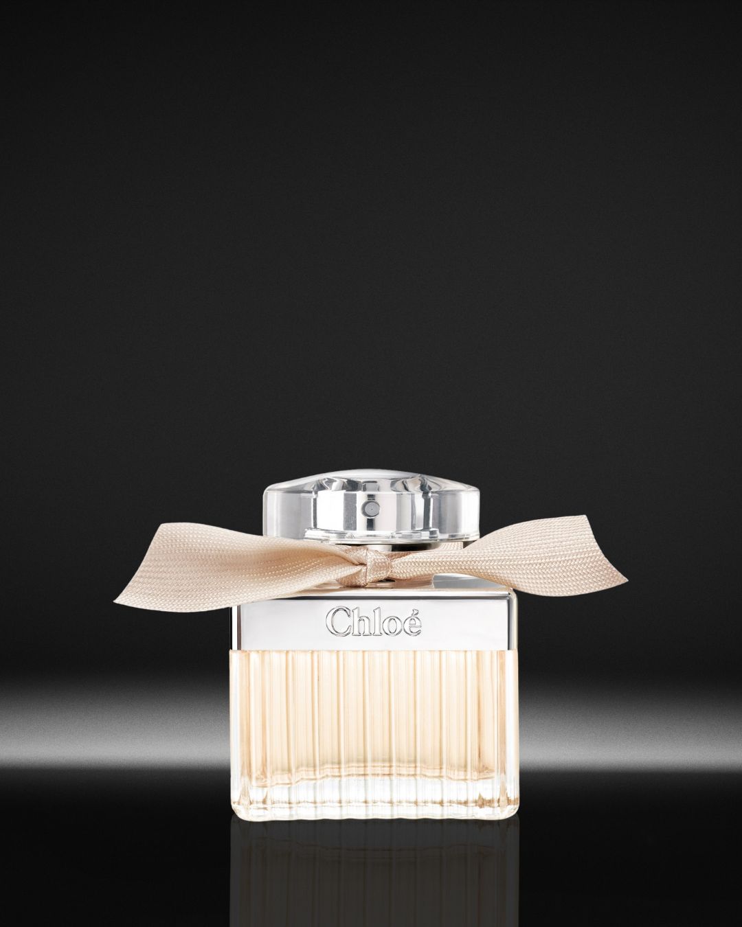 Chloé Eau de Parfum in een vierkante glazen flacon met een zachtroze lint en een zilveren dop, straalt een tijdloze en vrouwelijke elegantie uit.