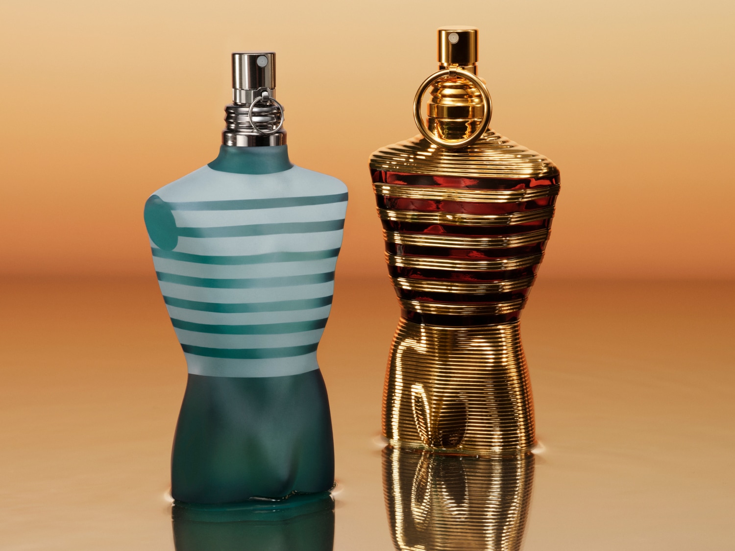 Dwa flakony perfum w kształcie torsu: jeden w niebiesko-białe paski, drugi w złote prążki, oba stojące na błyszczącej powierzchni.