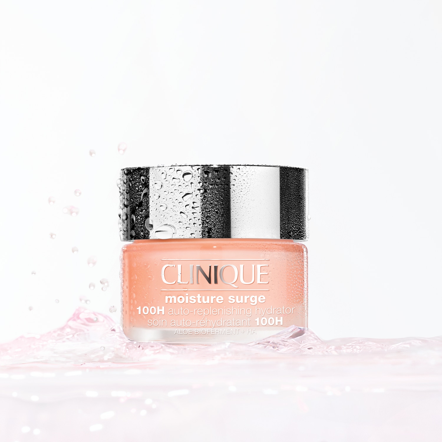 Voici le soin auto-réhydratant 100H Moisture Surge de Clinique, un gel crème rose pâle dans un pot transparent avec un couvercle argenté, conçu pour hydrater la peau.