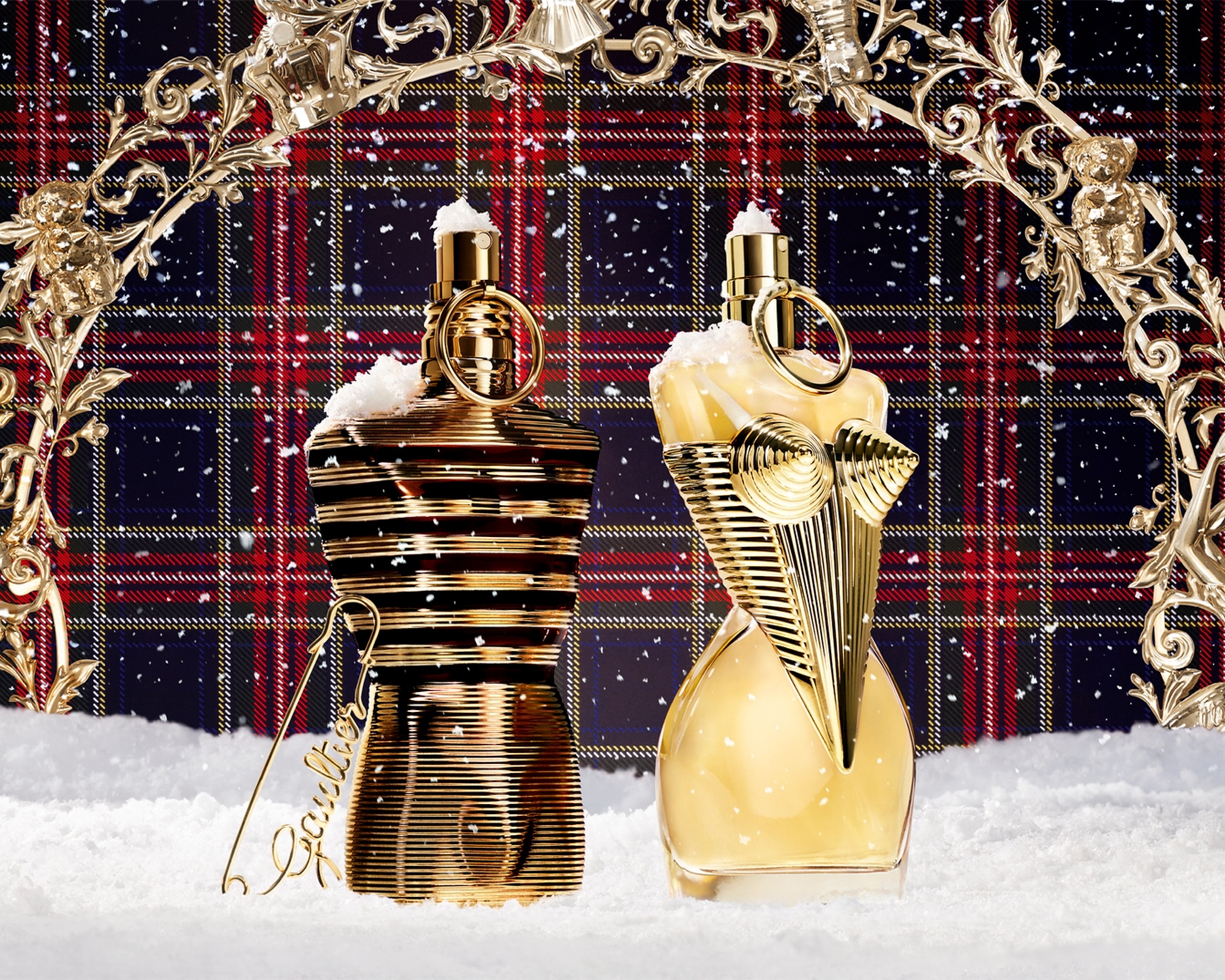 Découvrez les parfums Jean Paul Gaultier dans leurs flacons emblématiques en forme de buste, présentés dans un décor hivernal festif.