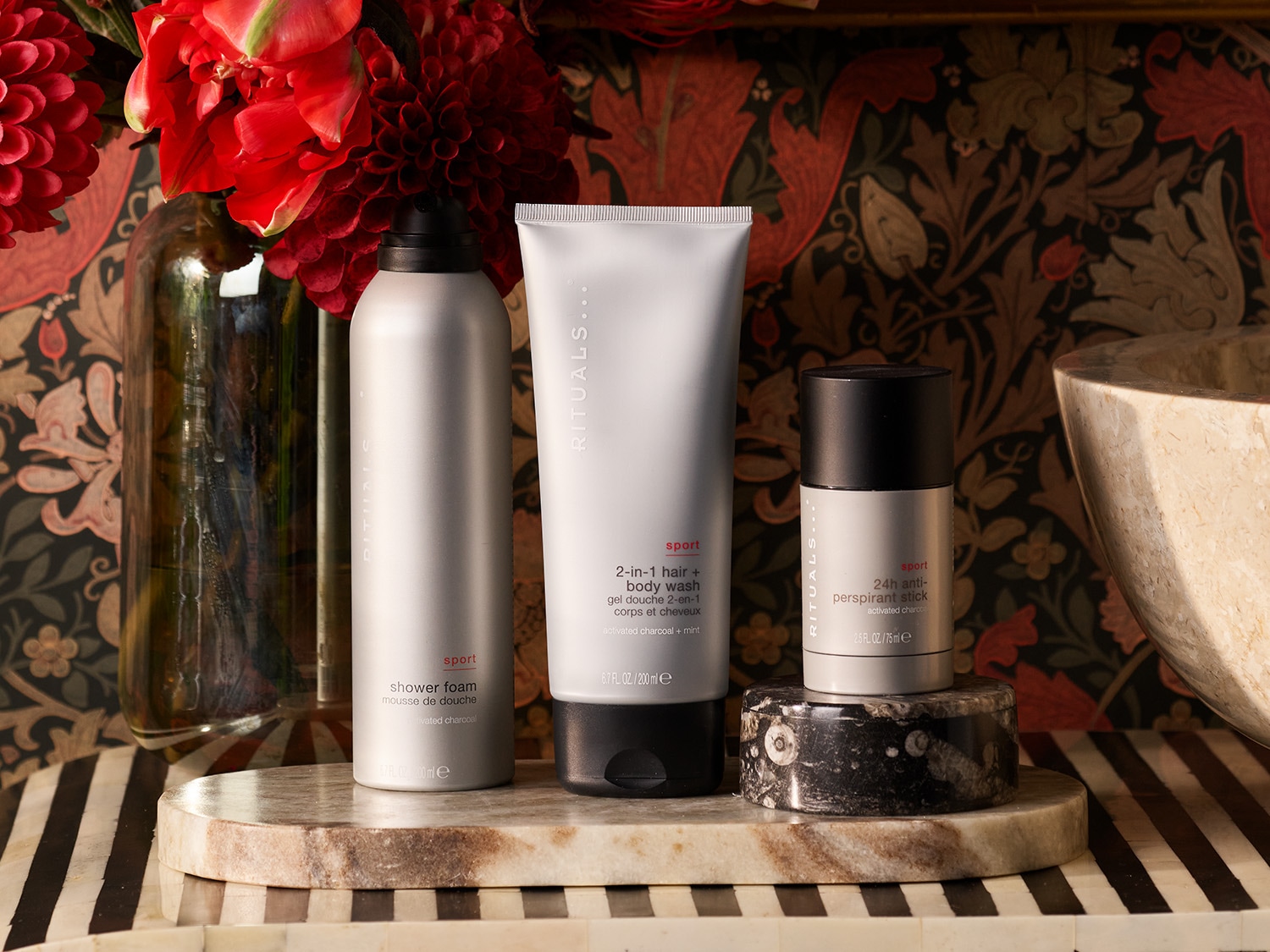 Sidabrinės spalvos „Rituals Sport“ dušo putos su aktyvuota anglimi, šalia 2-in-1 plaukų ir kūno prausiklis bei antiperspirantas.