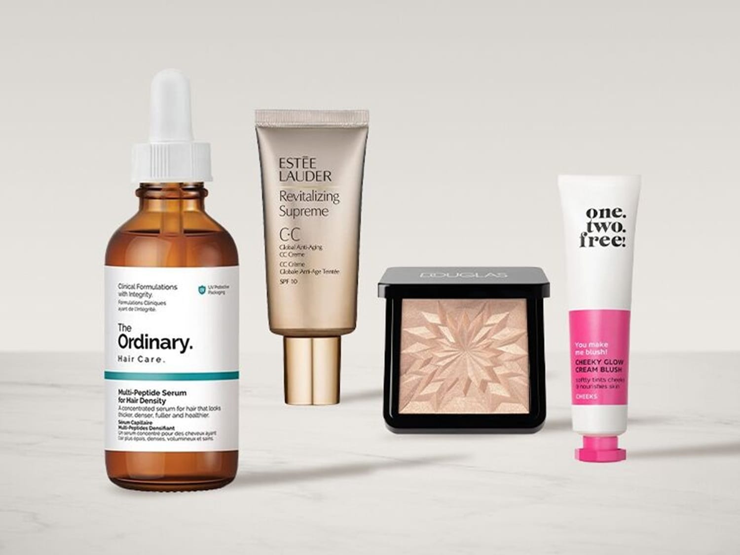 A The Ordinary Multi-Peptide szérum hajra, egy Estée Lauder Revitalizing Supreme CC krém SPF 10-zel, egy Douglas highlighter és egy One.Two.Free! Cheeky Glow krémpirosító látható.