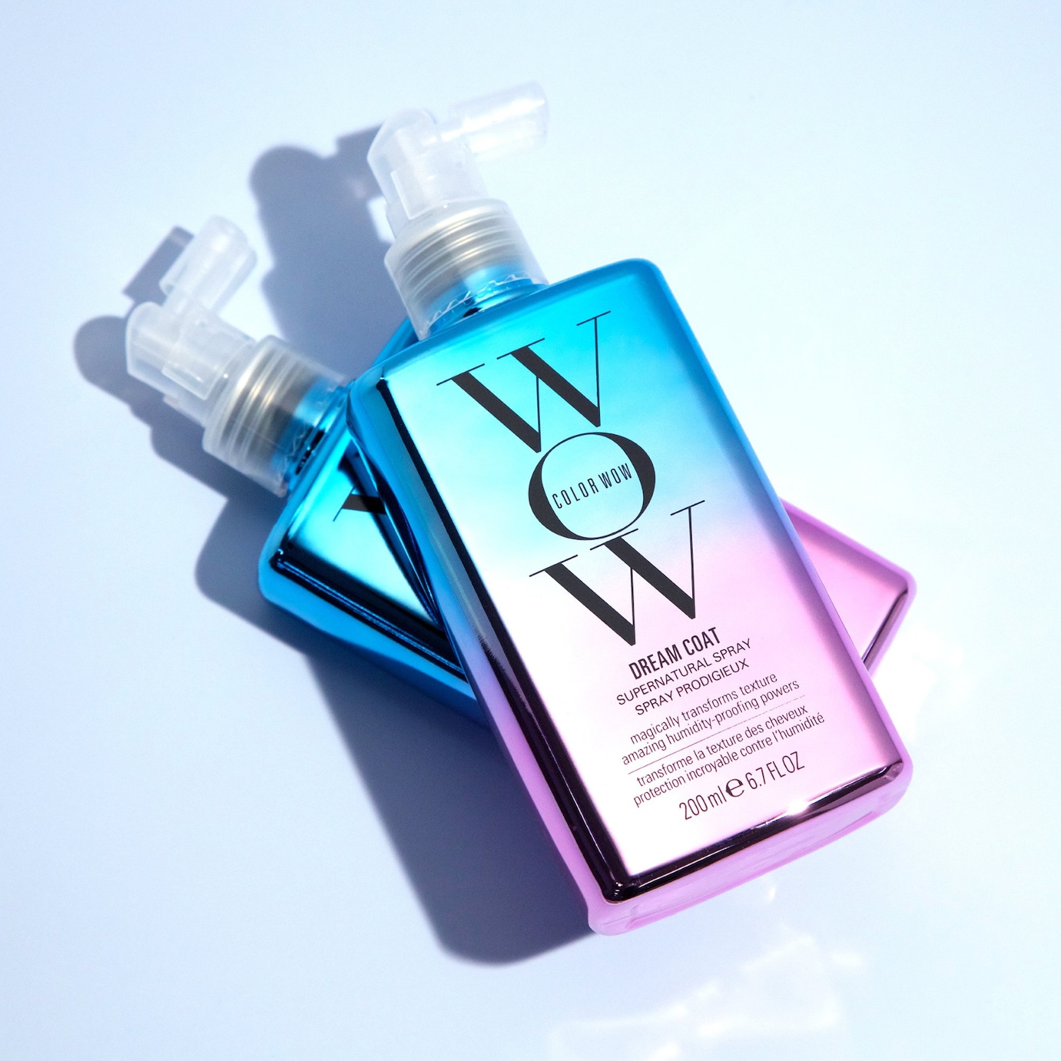 Zwei schimmernde Flaschen Color Wow Dream Coat Supernatural Spray, die magisch die Textur verwandeln und unglaublichen Schutz vor Feuchtigkeit bieten.