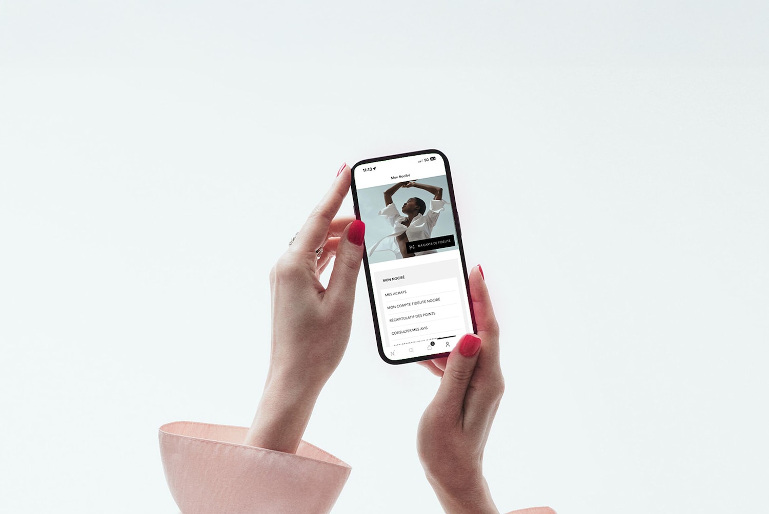 Un téléphone portable affiche l'application Mon Nocibé, où l'on peut voir les achats, le compte fidélité et consulter les avis.