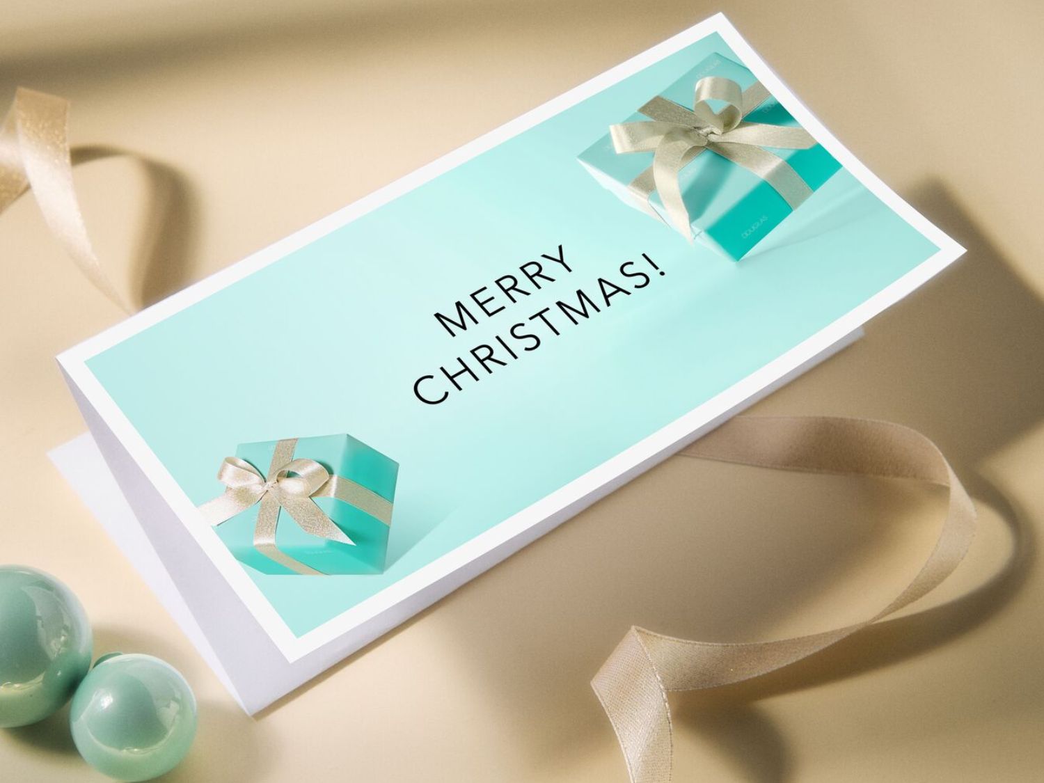 A képeslap világoskék színű, rajta a "Merry Christmas!" felirat, és két kis ajándékdoboz látható rajta, az ünnepi hangulatot fokozva.