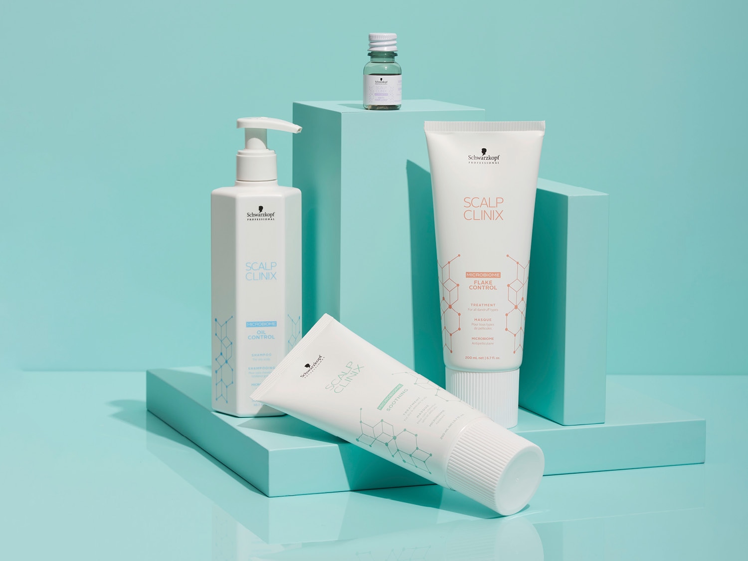 Na tle błękitu, zestaw kosmetyków Schwarzkopf Scalp Clinix: szampon w białej butelce z pompką, maska w tubie i mała buteleczka serum, wspierające zdrowie skóry głowy.