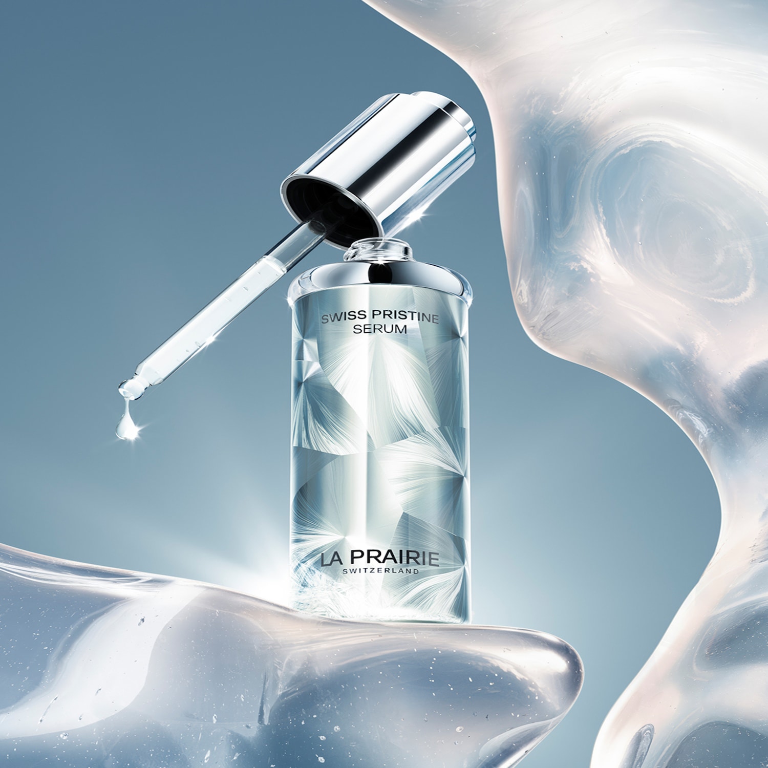 Serum La Prairie Swiss Pristine w eleganckiej butelce z pipetą, z kroplą serum spływającą z aplikatora, otoczone przezroczystymi, falującymi formami, które symbolizują czystość i nawilżenie.