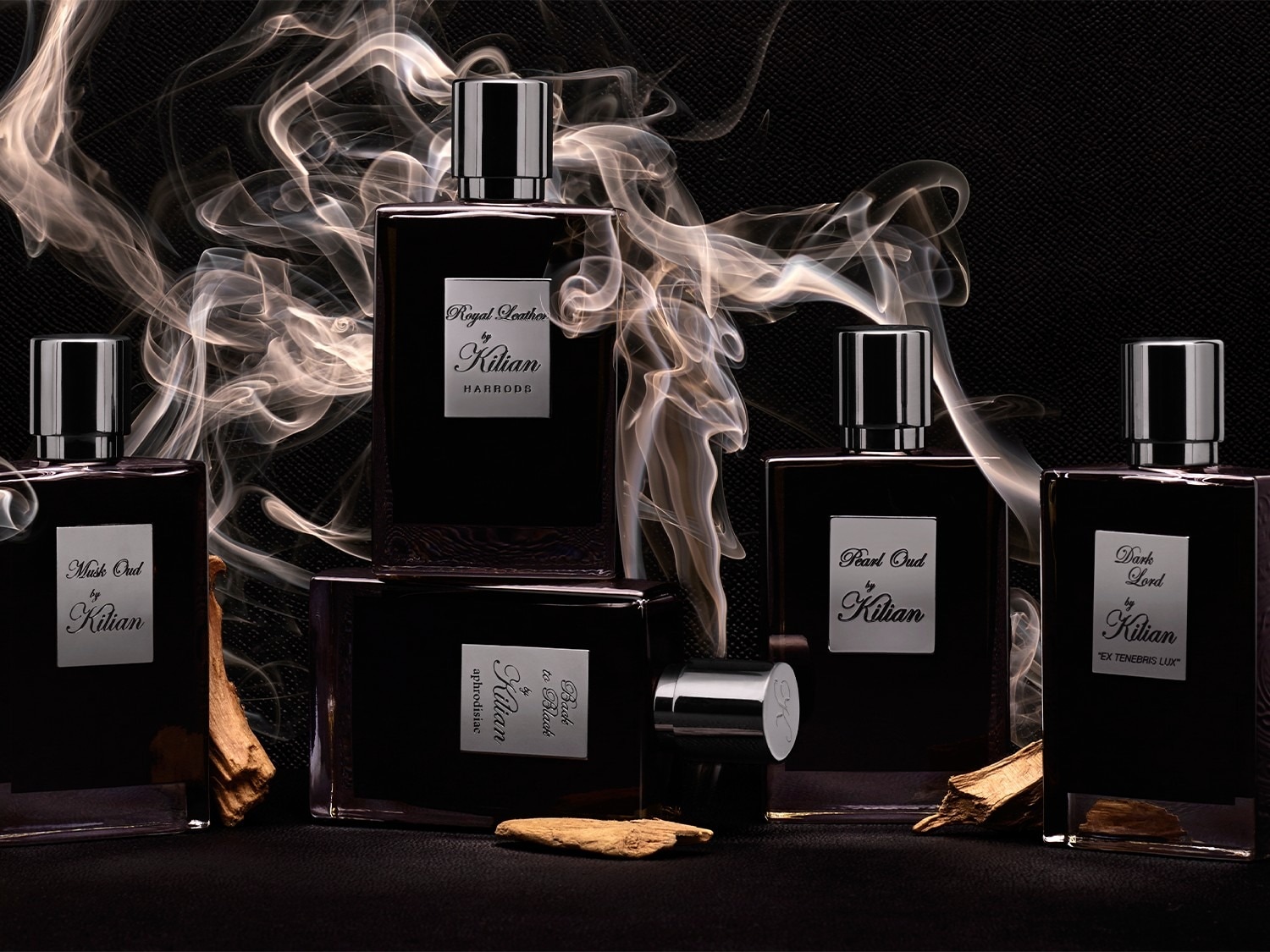 Découvrez la collection de parfums Kilian dans des flacons carrés noirs élégants, avec des noms tels que Royal Leather, Musk Oud, Pearl Oud et Dark Lord, présentés sur un fond sombre et mystérieux.