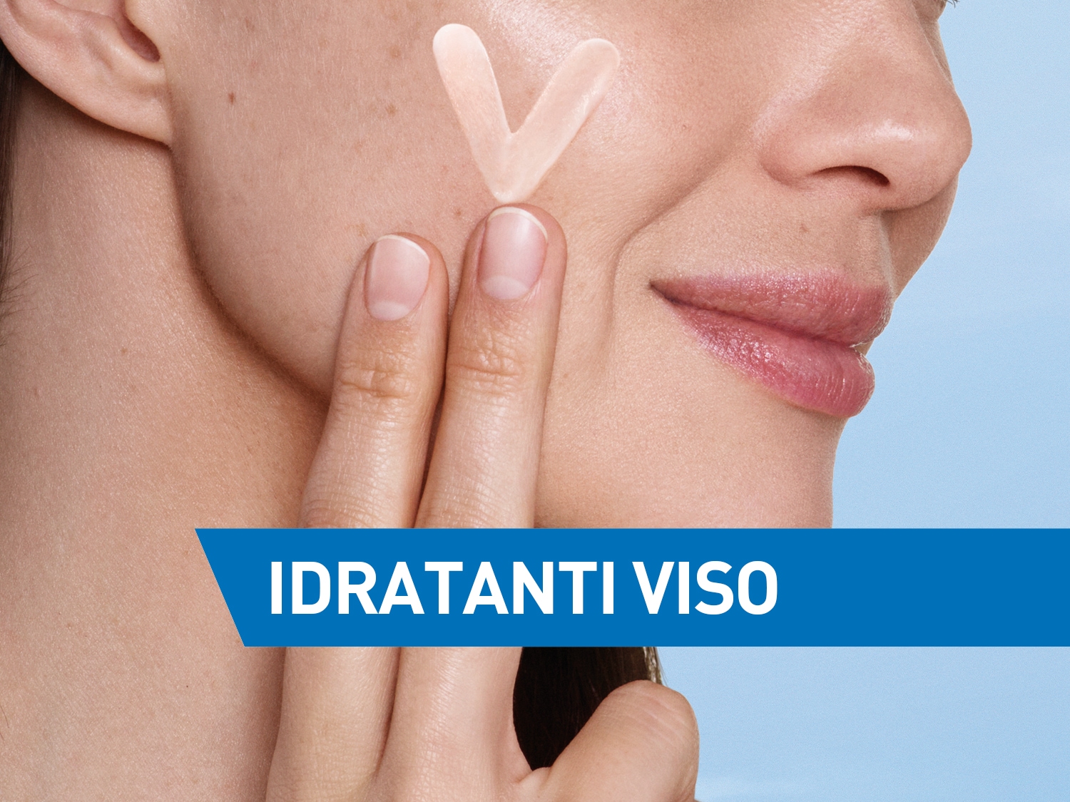 Primo piano di una donna che applica una crema idratante sul viso per nutrire e proteggere la pelle.