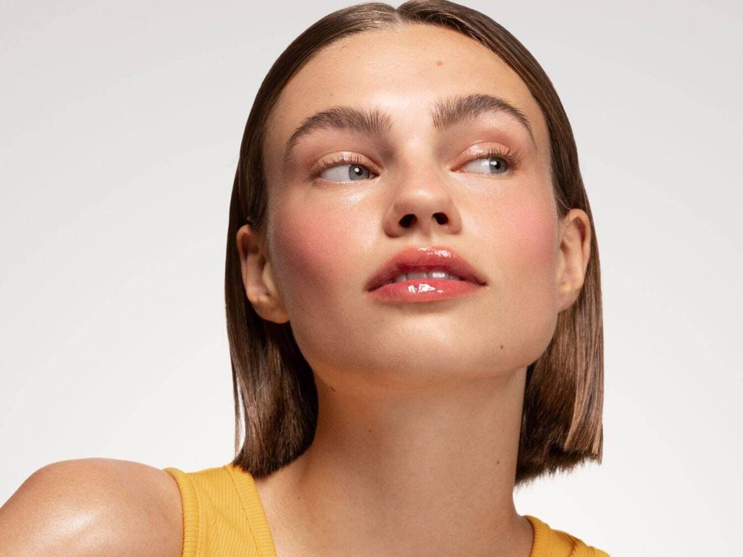 Découvrez un visage rayonnant avec un blush rosé délicat et des lèvres brillantes, sublimé par un teint frais et naturel.