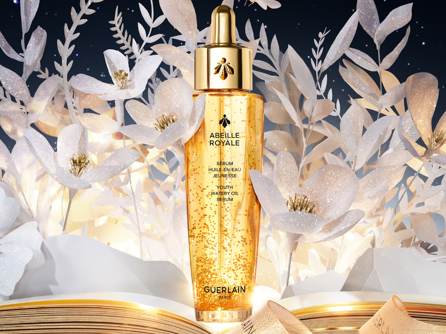 Butelka olejku do twarzy Guerlain Abeille Royale Youth Watery Oil z pipetą, wypełniona złotymi kropelkami, które obiecują młodzieńczy blask.