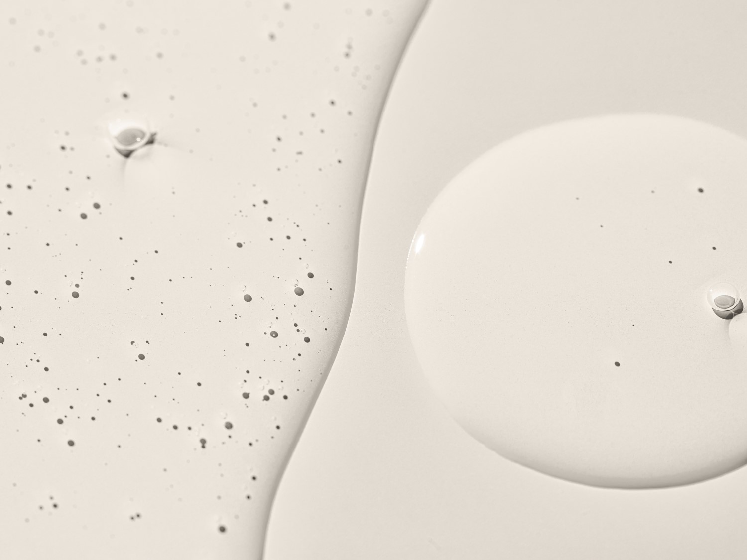 Detailní záběr na texturu pleťového séra s bublinkami a kapkami, které ukazují jeho jemnost a hydratační vlastnosti.