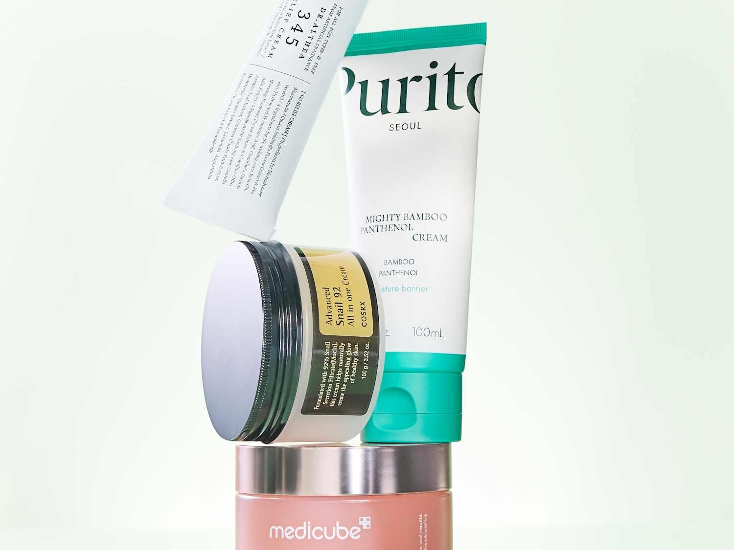 Eine Auswahl an Hautpflegeprodukten, darunter Dr.Althea Relief Cream, Purito Mighty Bamboo Panthenol Cream, COSRX Advanced Snail 92 All in one Cream und Medicube Creme.