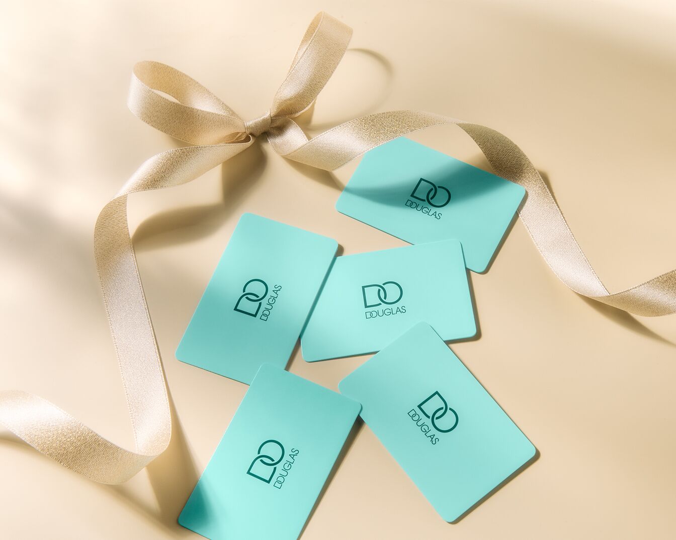 Świąteczna kartka Douglas z napisem 'Wesołych Świąt!' i grafiką prezentów w odcieniach błękitu i złota, otoczona wstążką i bombkami.