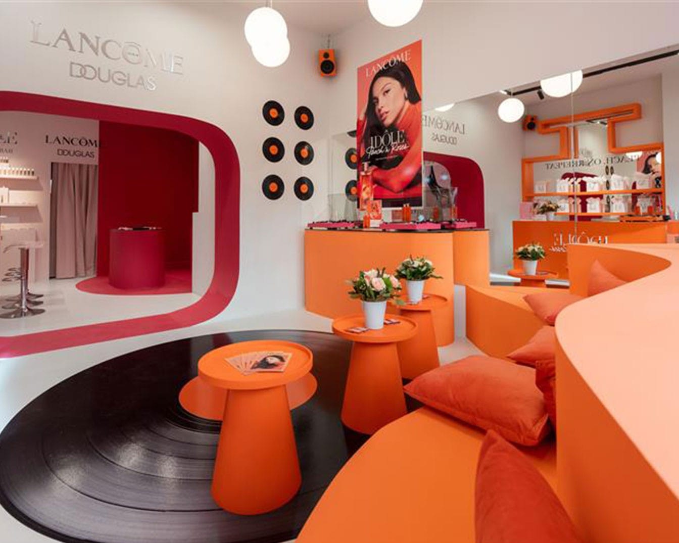 Innenaufnahme eines Douglas-Geschäfts mit Lancôme-Produkten, die in einem farbenfrohen, modernen Design präsentiert werden.