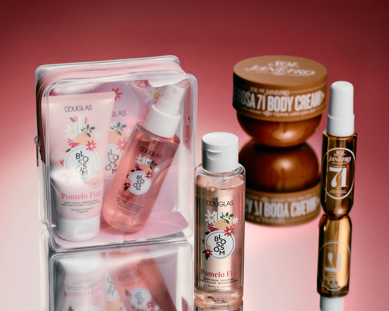 Découvrez l'ensemble de soins corporels Douglas Blossom, comprenant une lotion, un gel douche et un spray, le tout dans un sac transparent orné de fleurs.