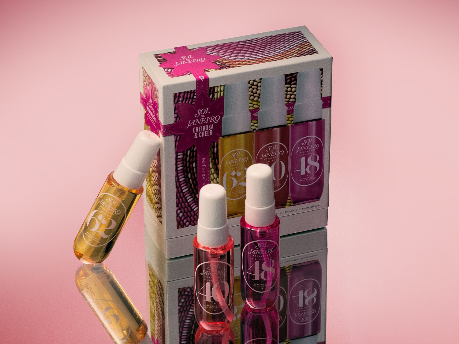 Découvrez le coffret Sol de Janeiro Cheirosa & Cheer, comprenant les brumes parfumées 62, 48 et 40, présentées dans un emballage festif orné d'un ruban rose.
