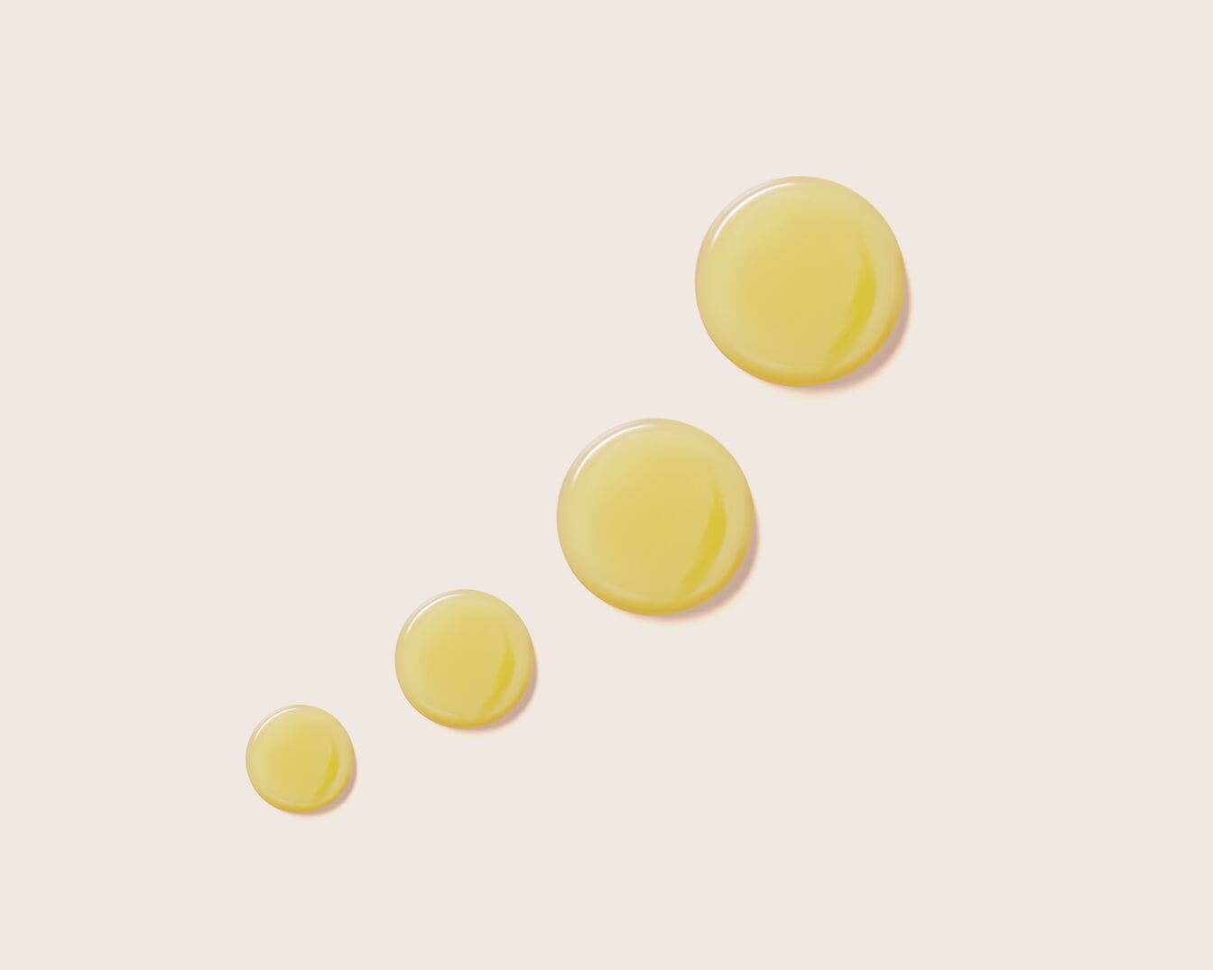 Nahaufnahme von vier gelben Öl- oder Serumtropfen unterschiedlicher Größe, die auf einem hellen Hintergrund aufgetragen sind und eine feuchtigkeitsspendende Textur zeigen.