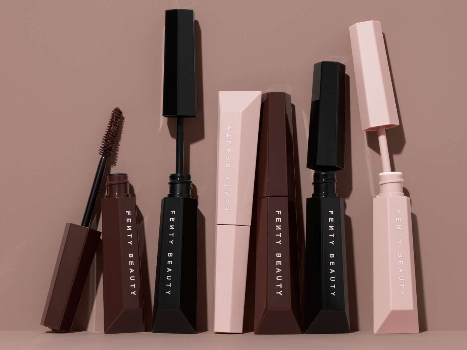 Découvrez la gamme de mascaras Fenty Beauty aux packagings noir, marron et rose pâle, conçus pour sublimer votre regard.
