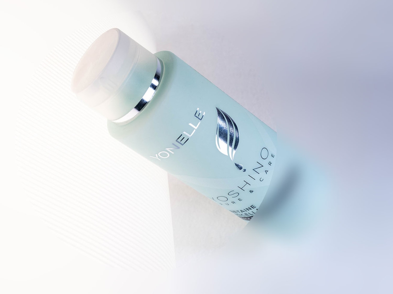 Błękitna butelka YONELLE YOSHINO PURE & CARE z srebrnymi napisami i grafiką liścia, leżąca na białym tle.