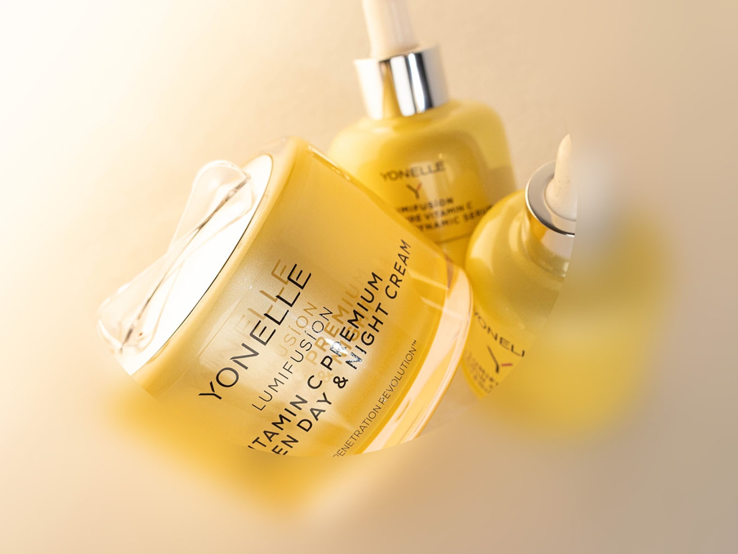 Żółte opakowania kremu na dzień i na noc Yonelle Lumifusion Premium z witaminą C oraz serum do twarzy z pipetą.