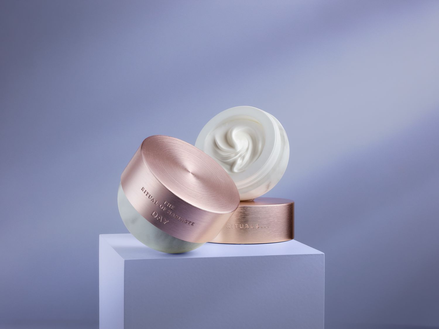 Die Ritual of Namaste Day Creme präsentiert sich in einer eleganten Verpackung mit roségoldenem Deckel und verspricht einen strahlenden Teint.