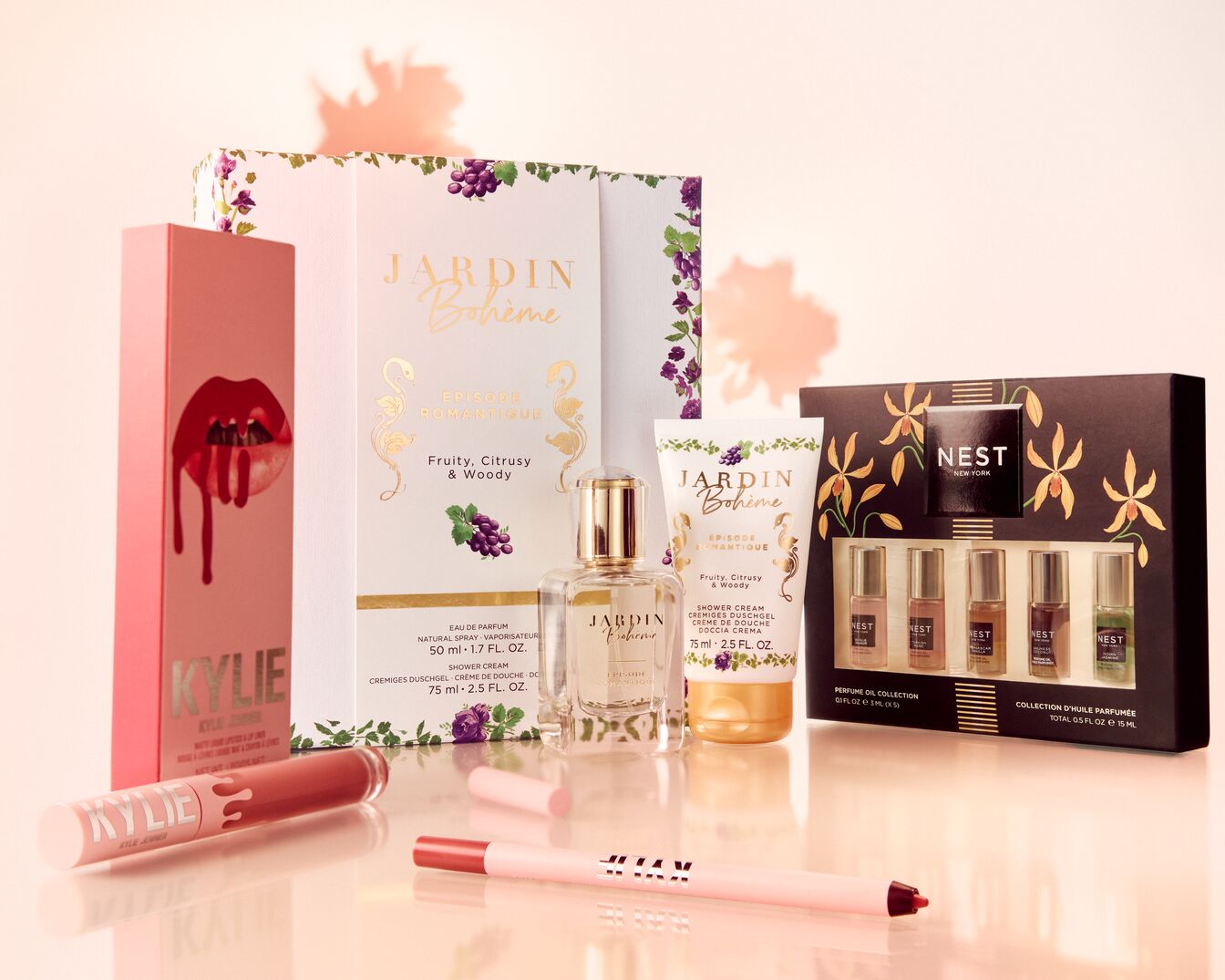 Eine Auswahl an Beauty-Produkten, darunter Kylie Cosmetics Lippenstift und Lipgloss, Jardin Bohème Parfüm und Duschgel sowie ein Nest New York Parfümöl-Set.