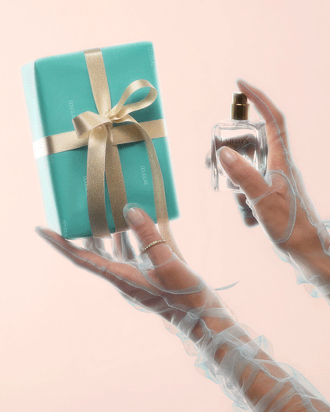 Ein türkisfarbenes Geschenk mit goldener Schleife und ein Parfüm werden von transparenten, langen Handschuhen gehalten.