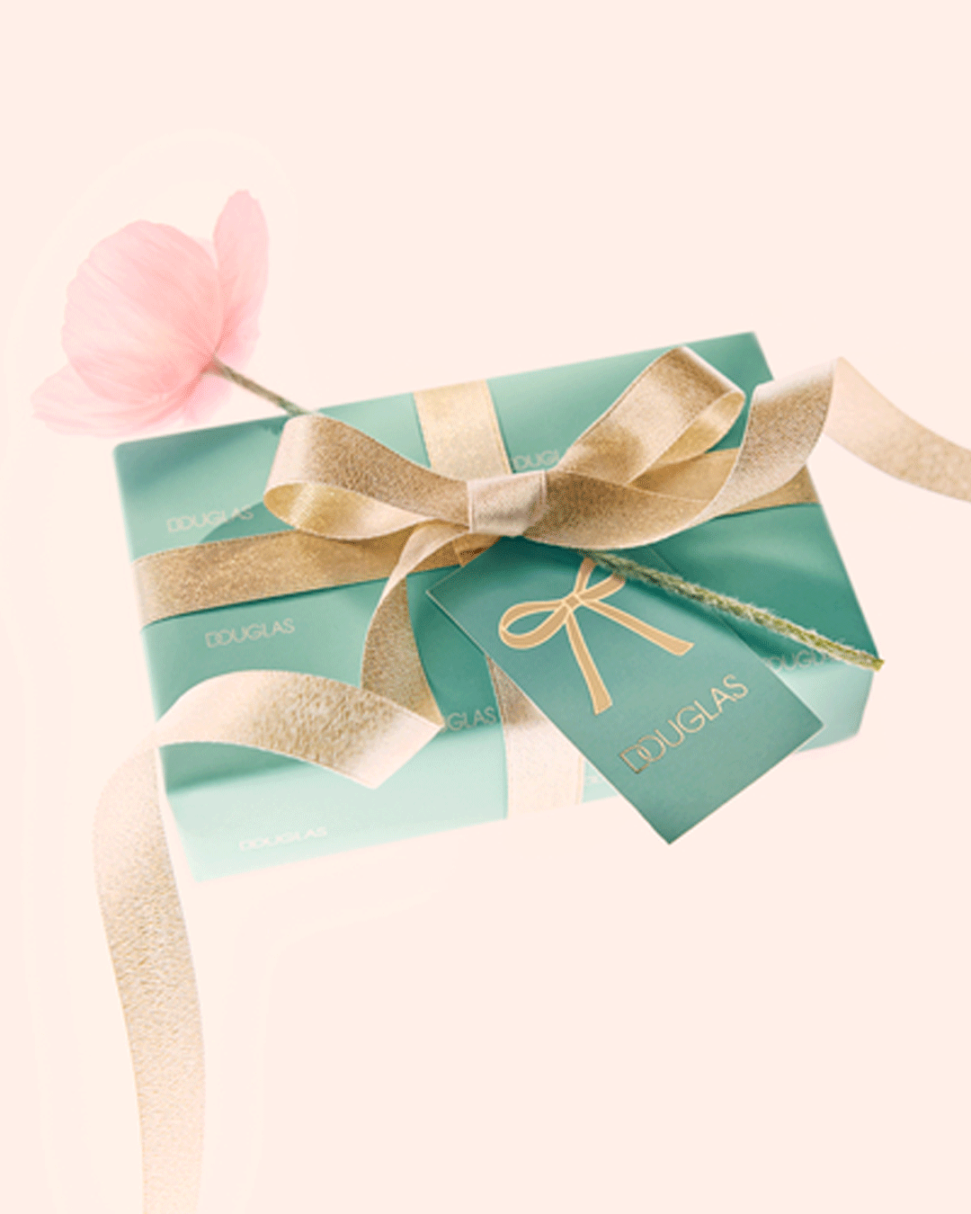 Ein mintgrünes Geschenk von Douglas, verziert mit einer goldenen Schleife und einem zarten rosa Blümchen, verspricht Freude.