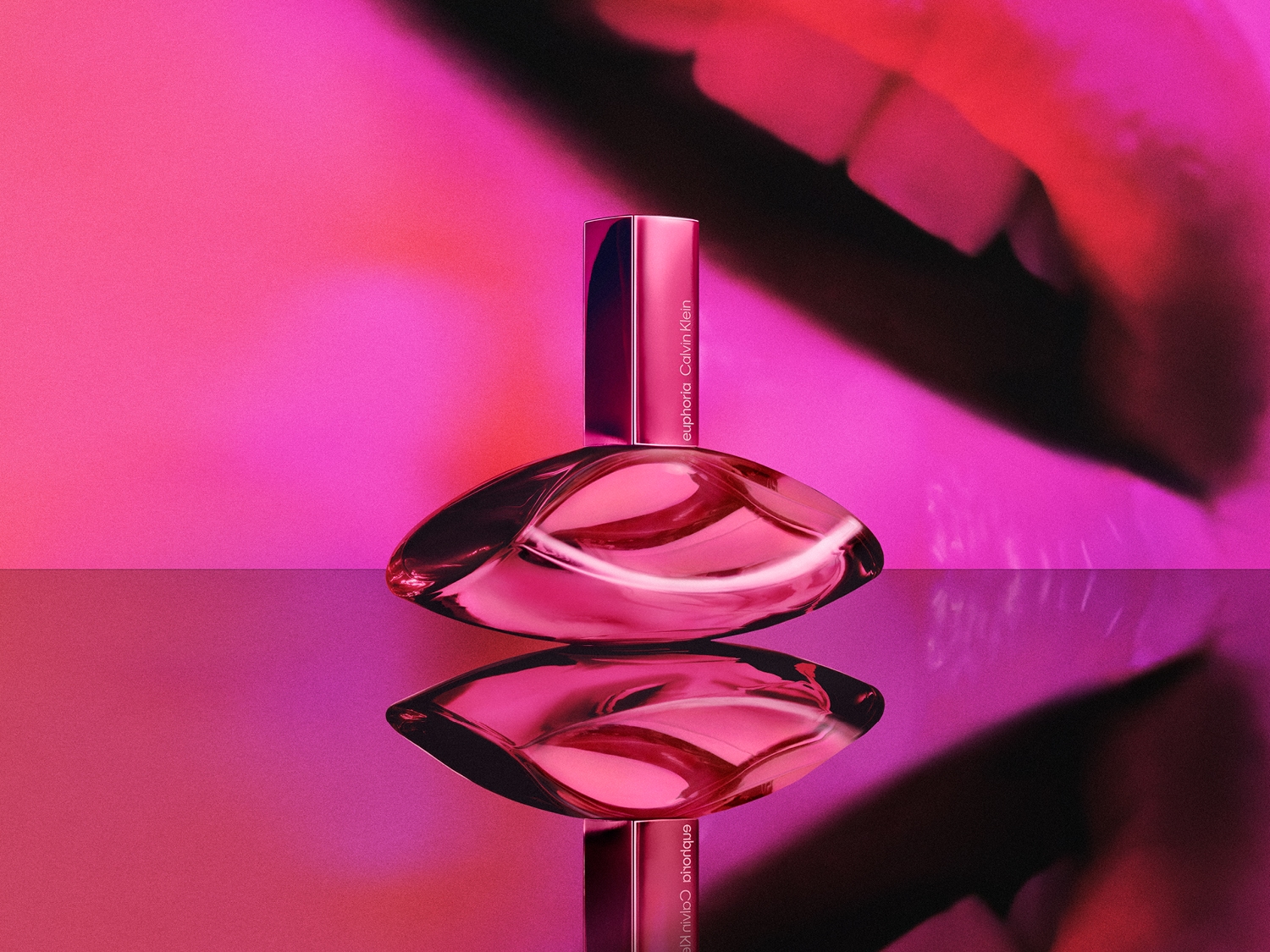 Der rosafarbene Calvin Klein Euphoria Duft präsentiert sich in einem eleganten Flakon, der auf einer glänzenden Oberfläche steht und sich darin spiegelt.