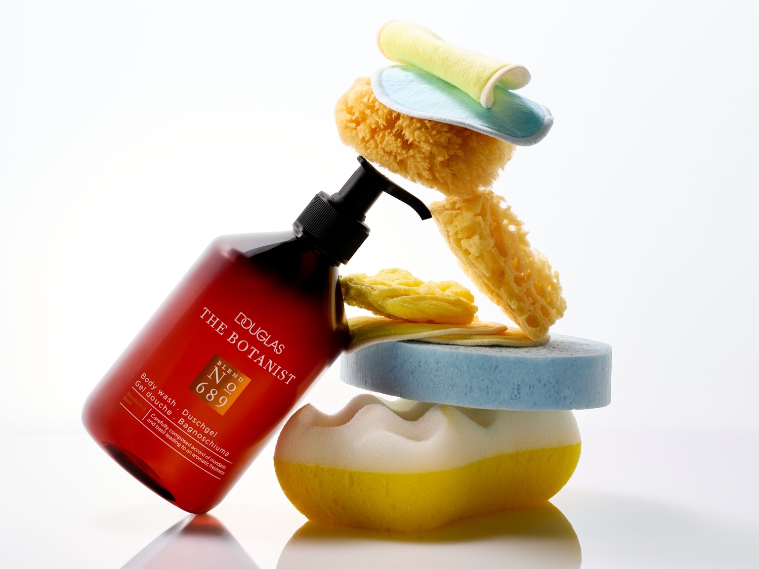 Das Douglas The Botanist No. 689 Duschgel mit Mandarinen- und Basilikumduft sorgt für aromatische Frische und ist zusammen mit verschiedenen Badeschwämmen und -utensilien abgebildet.