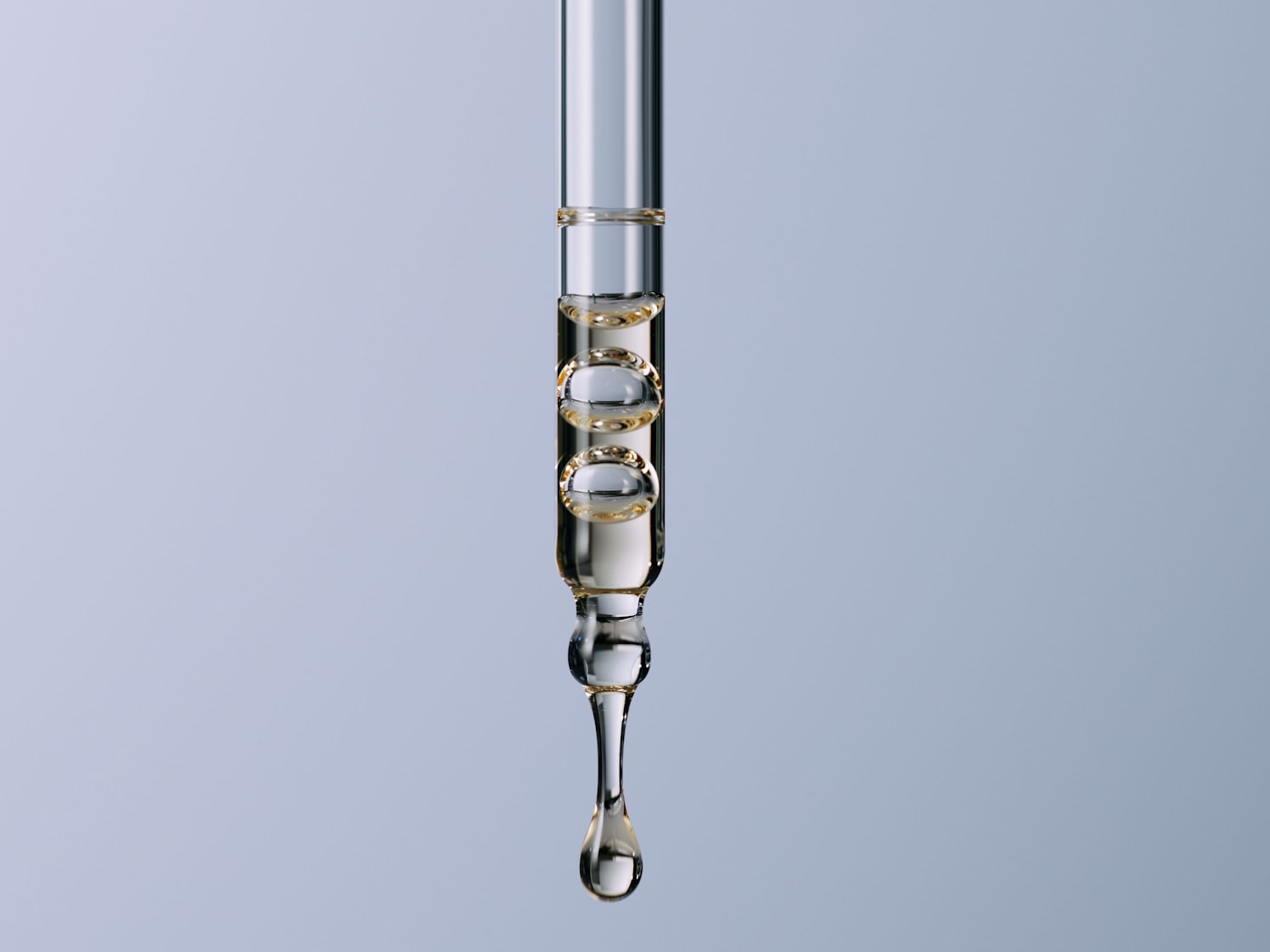 Nahaufnahme einer Pipette mit Serum, das eine klare, leicht gelbliche Flüssigkeit mit eingeschlossenen Luftblasen zeigt, die darauf wartet, aufgetragen zu werden.