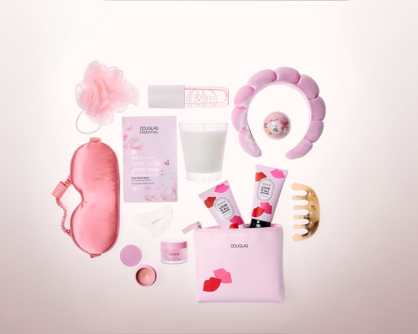 Rožinės spalvos grožio reikmenų rinkinys su „Douglas Essential“ rožių užpilta kauke, miego kauke ir „Love is All Around“ kremu, skirtas palepinti odą.