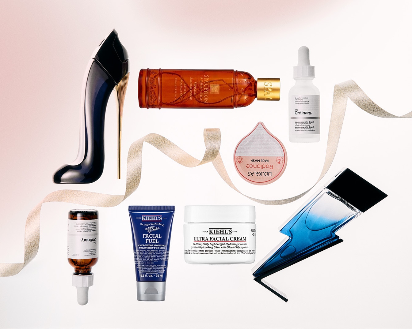 Nuotraukoje matomi įvairūs grožio produktai, įskaitant kvepalus aukštakulnio formos buteliuke, „Kiehl's“ veido kremą ir „The Ordinary“ serumą, išdėstytus ant balto fono su auksine juostele.