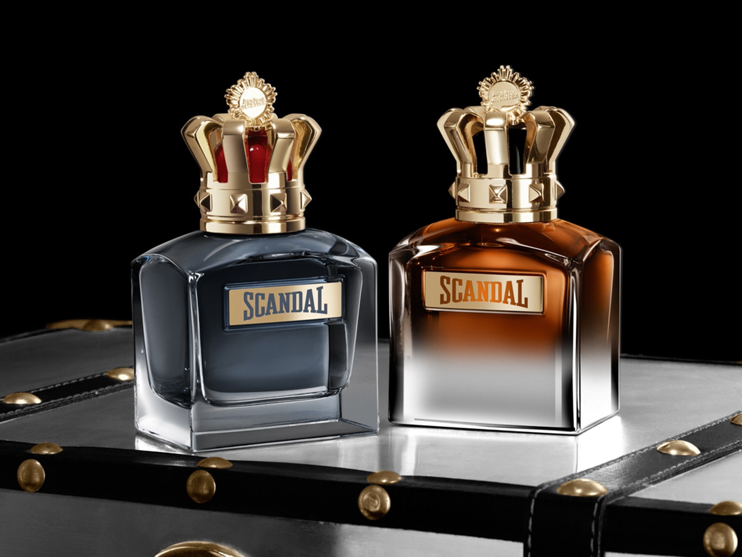 Découvrez Scandal pour Homme, un parfum audacieux présenté dans un flacon élégant surmonté d'une couronne dorée.