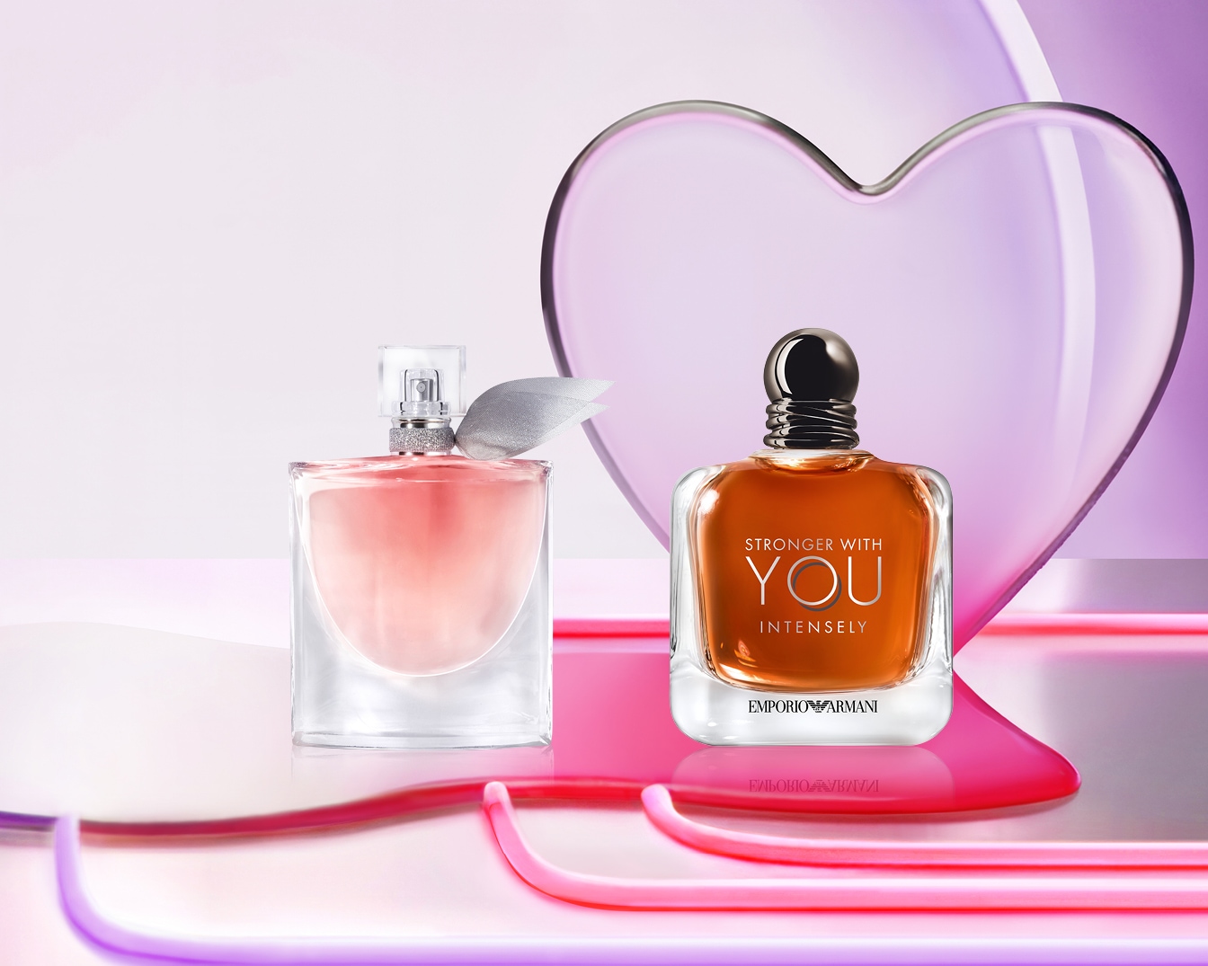 Twee parfumflessen, een roze en een amberkleurige, staan elegant voor een doorschijnend hart, klaar om je zintuigen te betoveren.