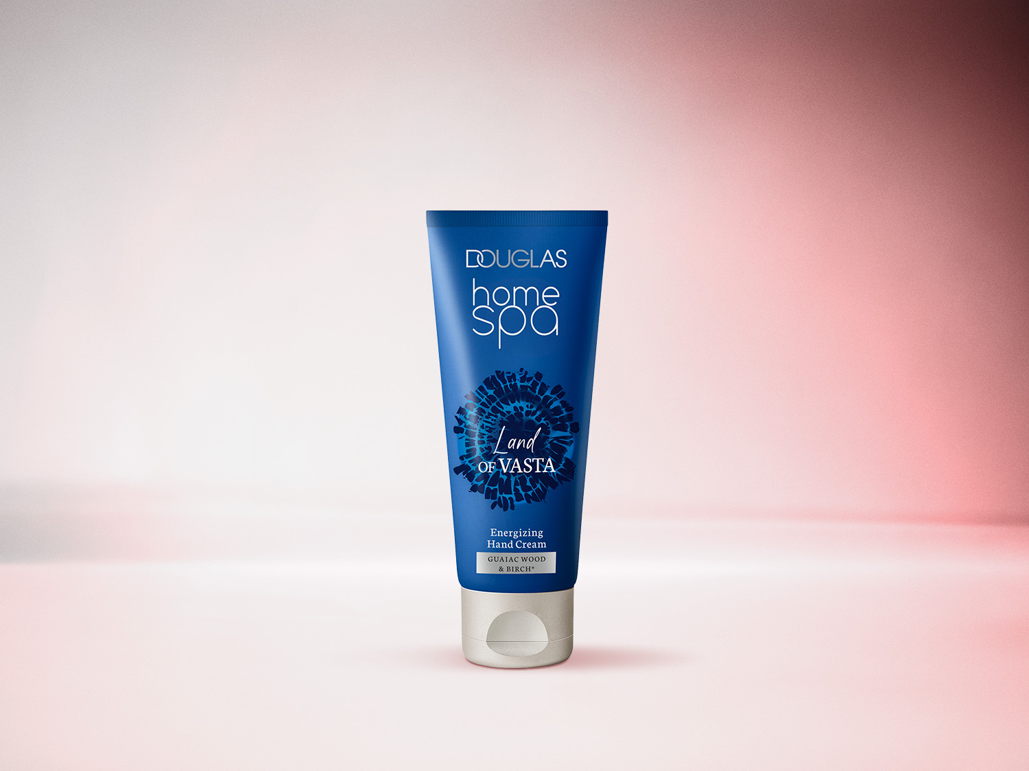 Die Douglas Home Spa Handcreme Land Of Vasta in einer dunkelblauen Tube mit silbernem Deckel, die eine luxuriöse Pflege mit Guajakholz- und Birkenextrakten verspricht.
