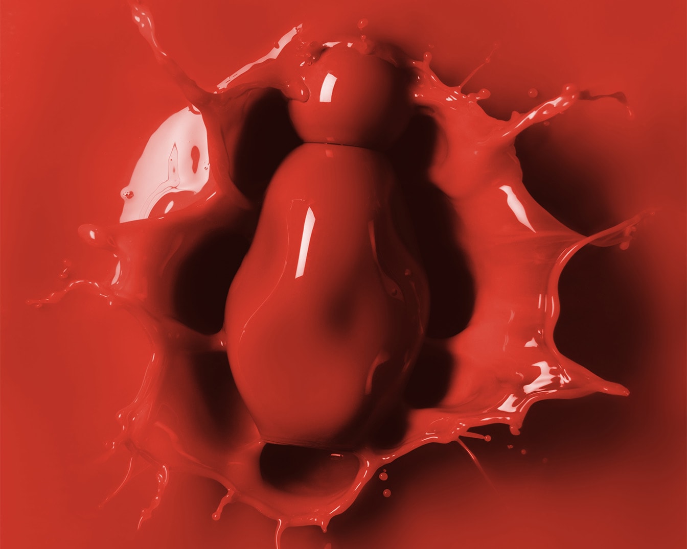 Eine rote, glänzende Matroschka-Puppe fällt in eine rote Flüssigkeit und erzeugt Spritzer.