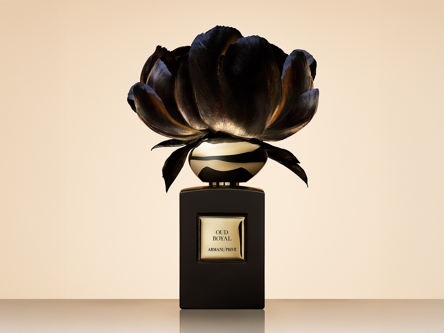 Découvrez Oud Royal d'Armani/Privé, un parfum luxueux présenté dans un flacon noir orné d'une fleur sombre et élégante.