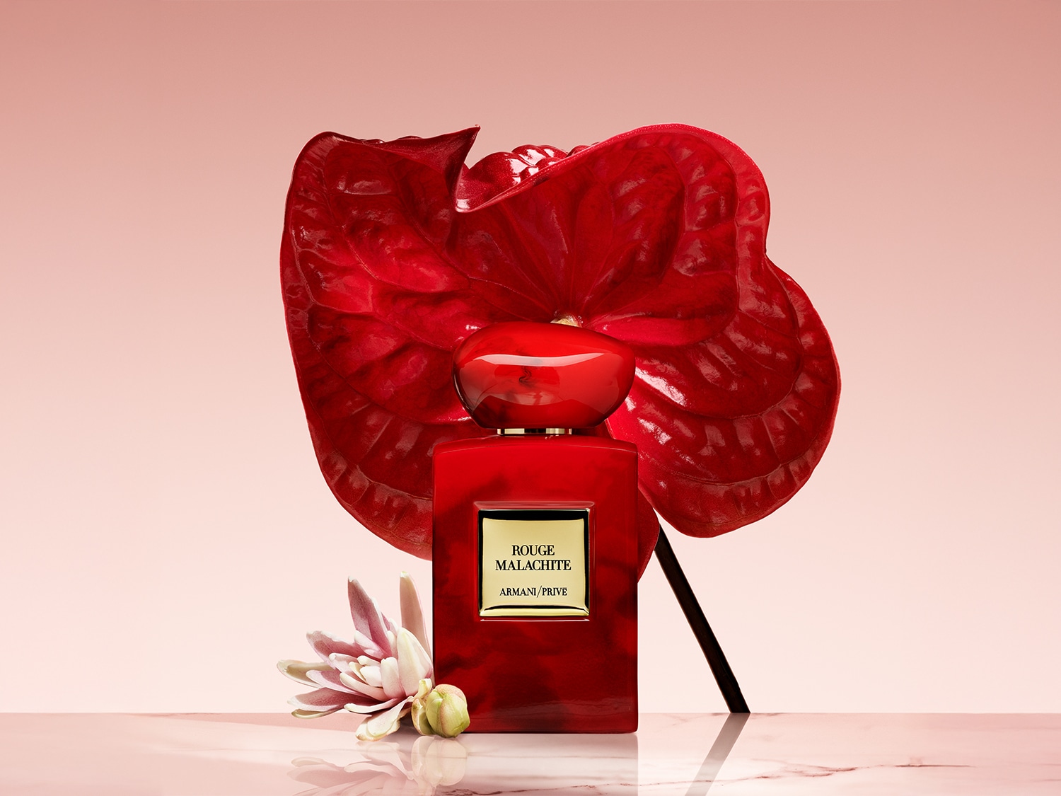Découvrez Rouge Malachite d'Armani Privé, un parfum captivant dans un flacon rouge vibrant, orné d'une fleur rouge luxuriante et d'une délicate fleur blanche.