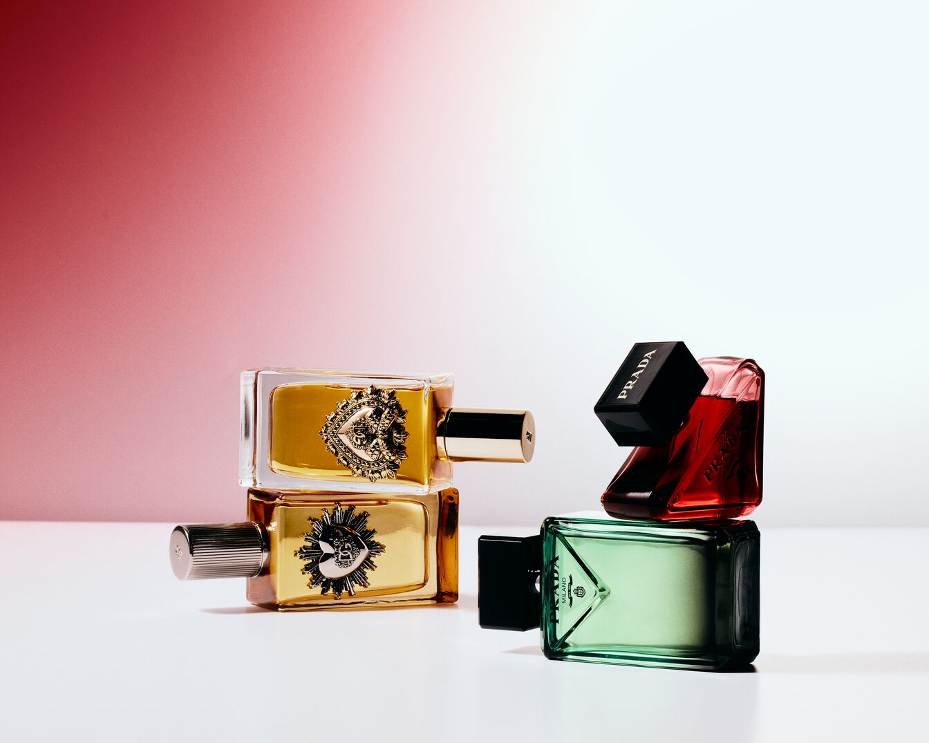Scopri le fragranze Prada: flaconi rettangolari con tappi neri, nei toni oro, rosso e verde, un'esplosione di colori e profumi.