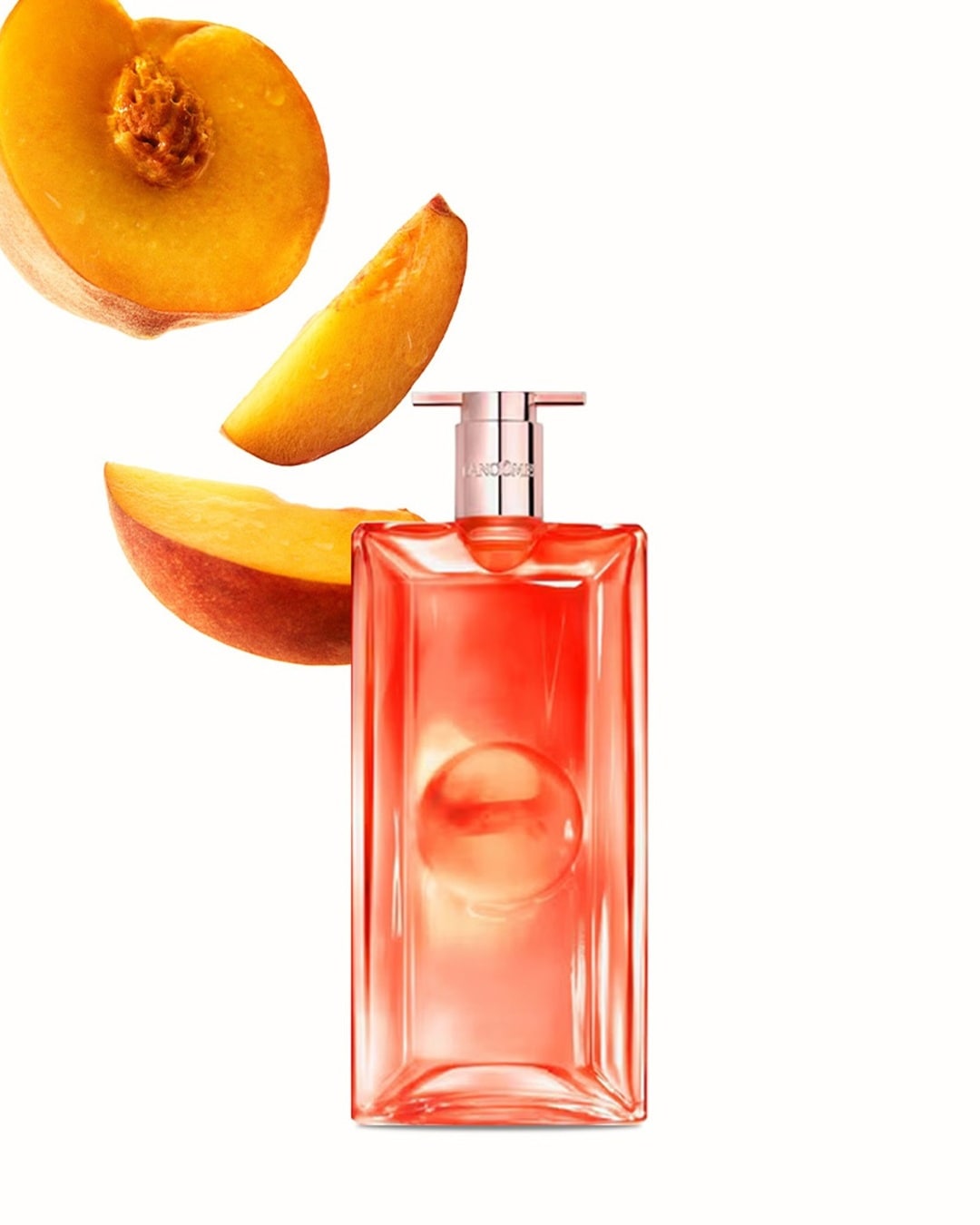 Pfirsichfarbener Lancôme Idôle Flakon mit Pfirsichstücken, die den Duft und die fruchtige Note des Parfums hervorheben.
