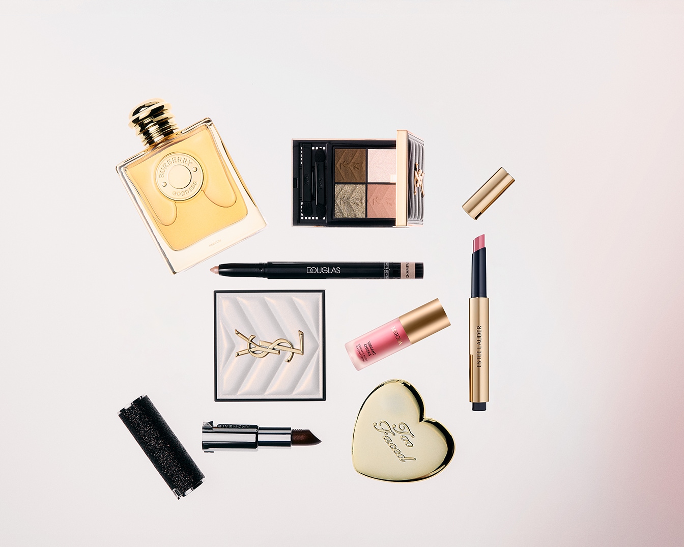 Découvrez un assortiment de produits de beauté, incluant un parfum Burberry, une palette d'ombres à paupières YSL, un crayon Douglas, un blush YSL, un gloss Excea, un rouge à lèvres Estée Lauder, et un fard Too Faced.